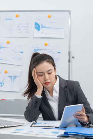 托腮在办公位上努力的女白领实拍图