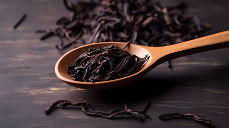 棕色木勺装黑叶红茶摄影图片