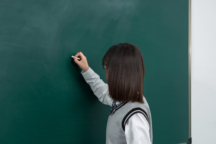 在黑板上回答问题的女生高清图版权图片下载