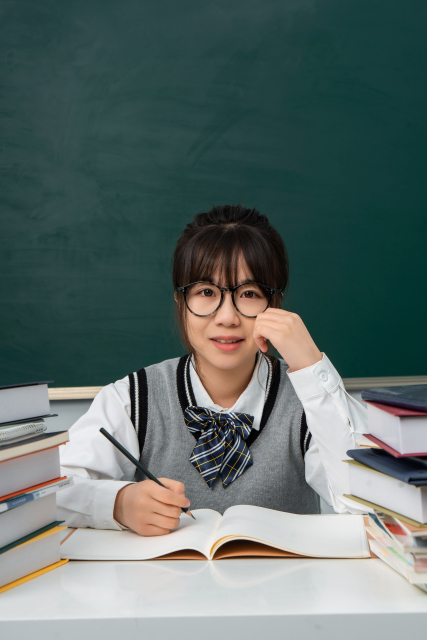 绿色黑板前的高中生实拍图