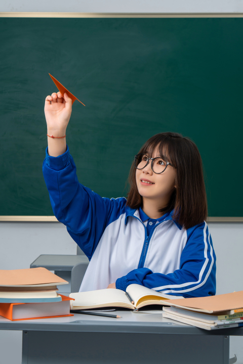 坐在课桌前面的女学生高清图版权图片下载