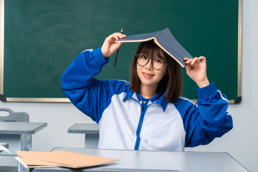 拿着书本不认真读书的女同学高清图