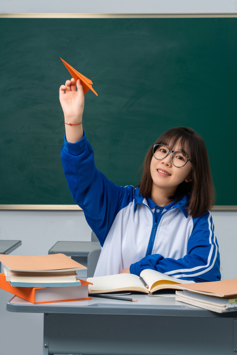 手拿纸飞机的女学生高清图版权图片下载