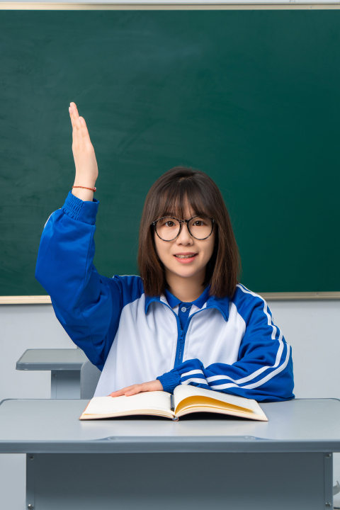 课堂上举手回答问题的女学生高清图版权图片下载