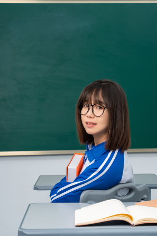抱着书本斜坐的女同学高清图