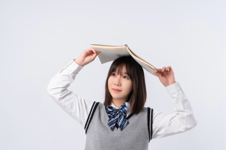 头顶书本眺望远方的学生实拍图