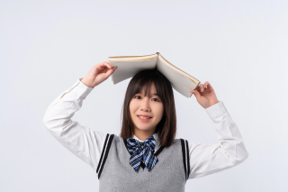 头顶书籍的俏皮学生实拍图