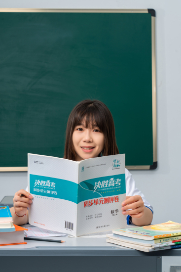 拿着课本专注学习的女生高清图