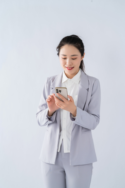 低头看手机的商务女性实拍图