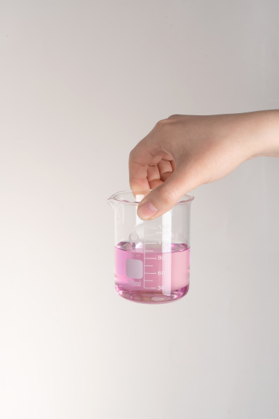 透明玻璃烧杯盛满粉色液体实拍图