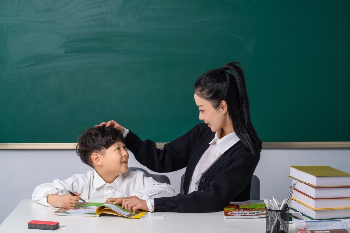 摸头鼓励学生的女老师高清图版权图片下载