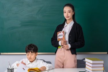 教室中辅导学生功课的女老师高清图