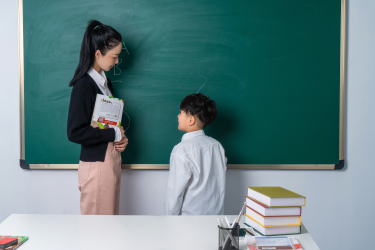 黑板前面看向老师的学生高清图