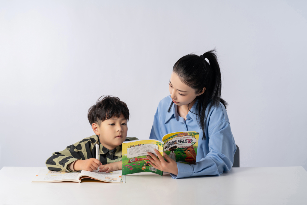 拿着课本教孩子功课的母亲高清图版权图片下载