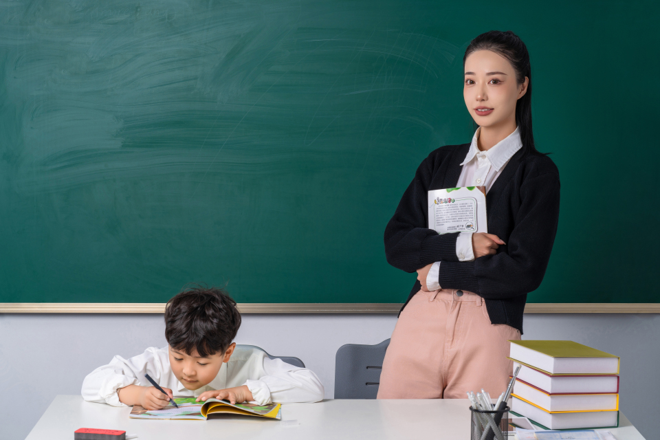 抱着课本的老师和写作业的学生实拍图