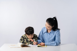 奋笔疾书的孩子和一旁的妈妈高清图