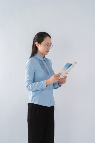 低头看教案的女老师实拍图