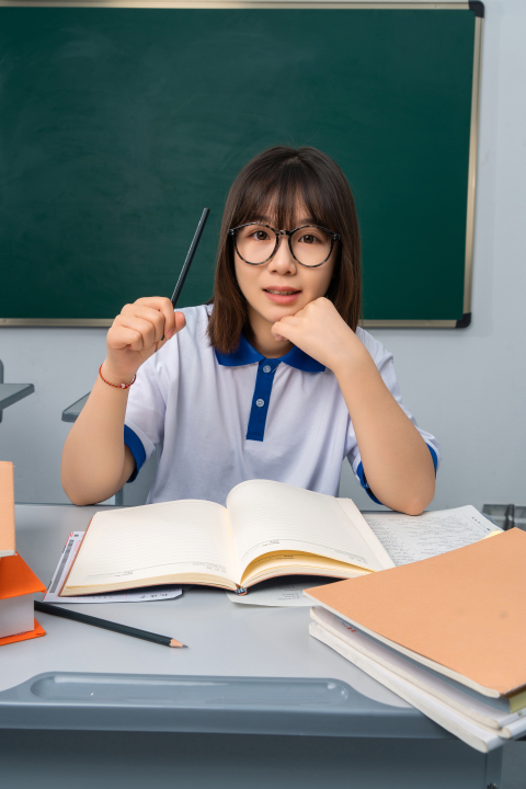 课桌上面的书本和学生高清图版权图片下载