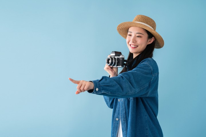 拿着相机手指向别人的女生高清图版权图片下载