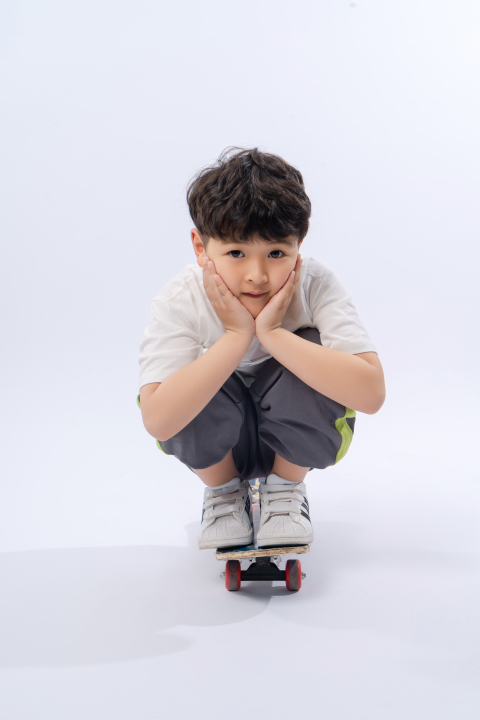 一个蹲在滑板的男孩写真图版权图片下载