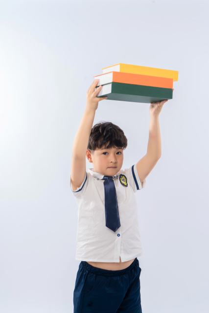 将书举过头顶的小男生高清图
