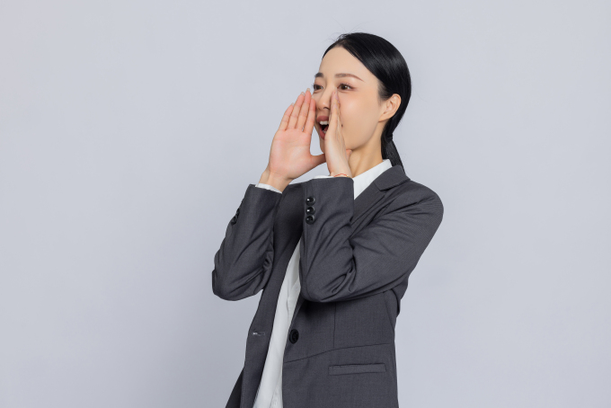 手放在嘴边呐喊动作的女性职业照高清图