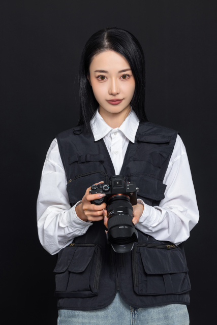 女摄影师拿单反相机工作高清图