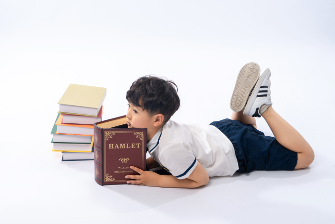 趴在书堆上的小男孩高清图