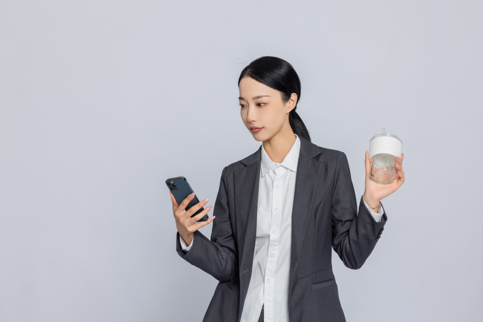 职业装女性看手机实拍图