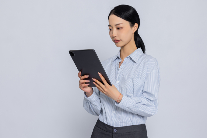 老师手拿平板搜索资料高清图