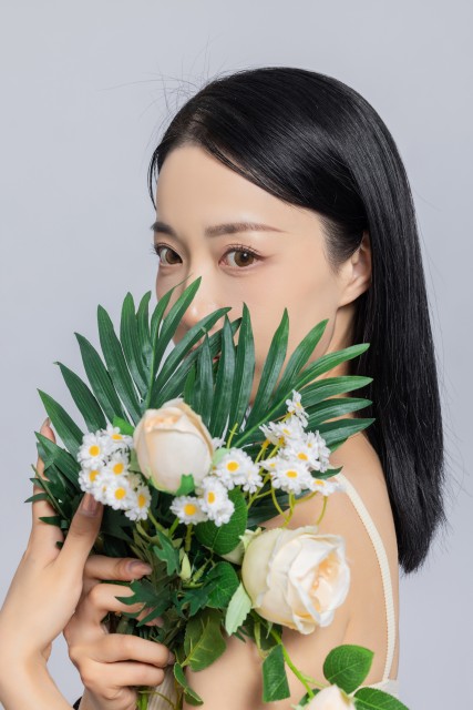 女生手捧鲜花遮挡面部实拍图