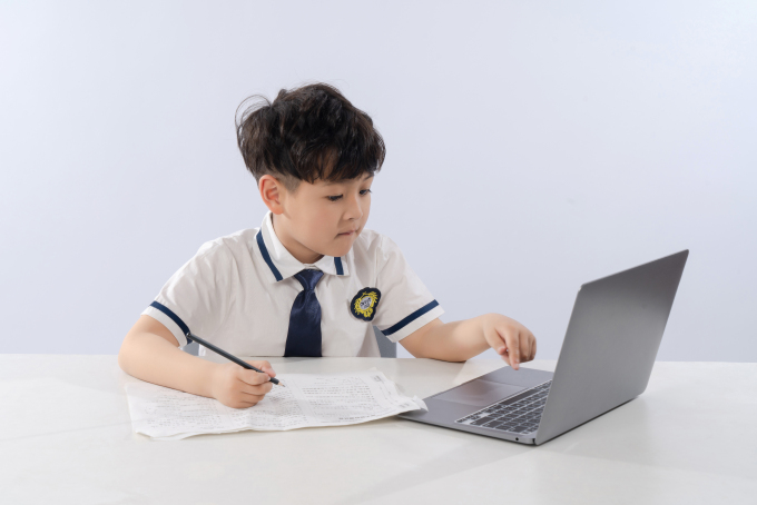 边上网课边做笔记的小男生高清图