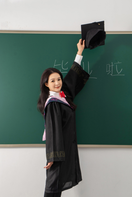 高举博士帽的毕业女生高清图