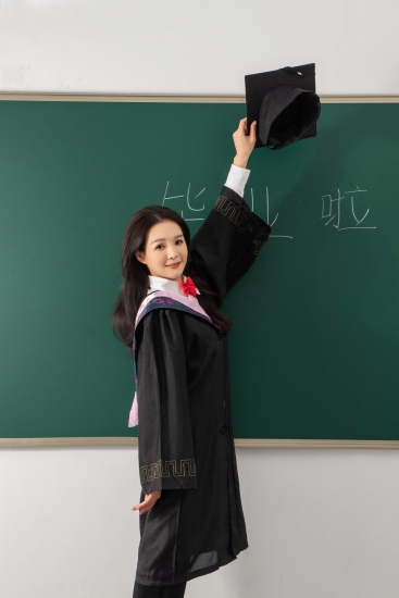 高举博士帽的毕业女生高清图