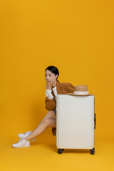 端庄大气扶着行李箱坐着的女生高清图