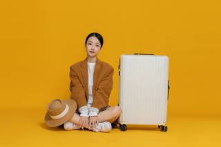坐在行李箱一旁的女生实拍图