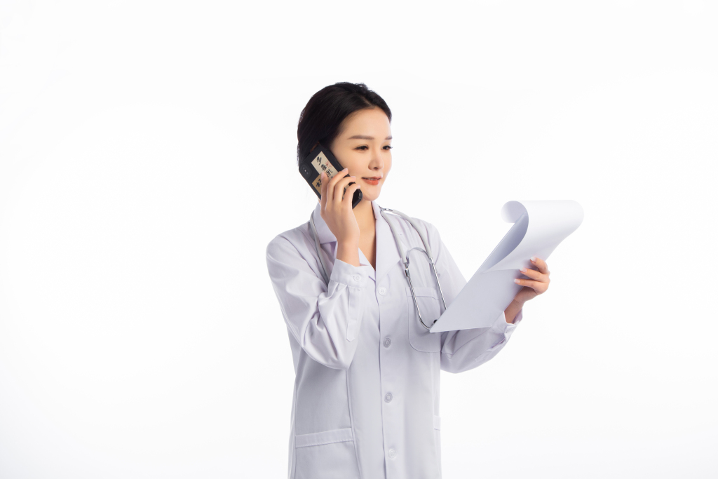 白色工装女医生看资料打电话高清图版权图片下载