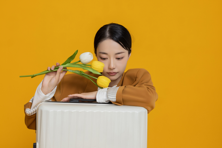 白色行李箱后的鲜花女生高清图版权图片下载