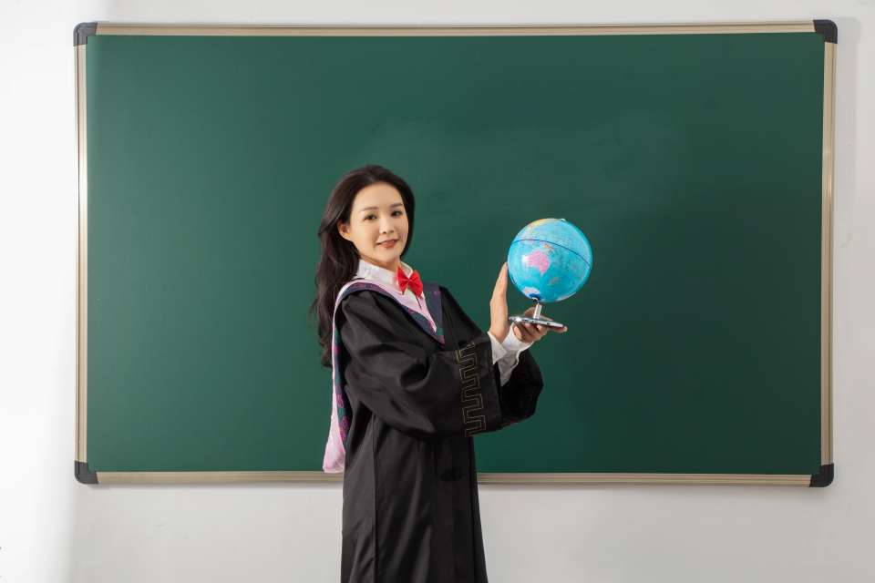 拿地球仪的毕业女生高清图
