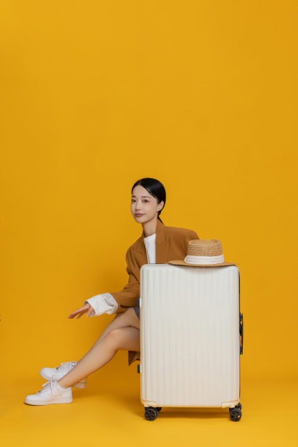 坐在行李箱后面休息的女生实拍图