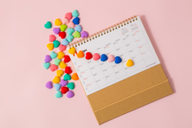 日历和粉色桌子上的糖果摄影图片