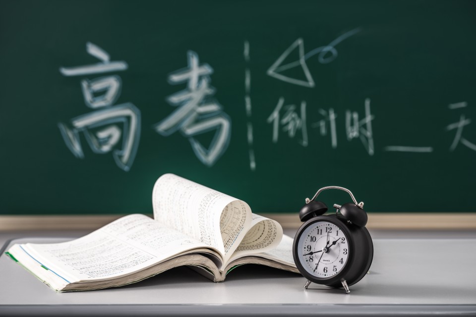 黑板前面的书本和闹钟高清图