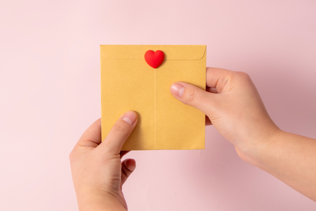 手持纸信封红色爱心摄影版权图片下载