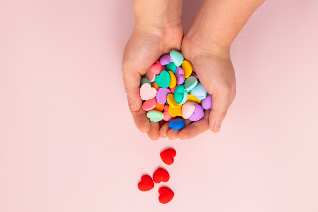 五彩心形糖果洒在手上的摄影版权图片下载