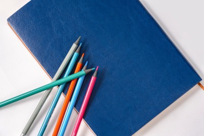 一个蓝色的笔记本和六支铅笔高清图