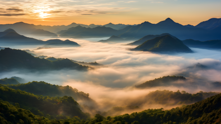 雾中日出的山谷与山峰摄影图