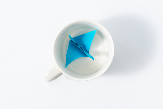 白色杯子里放着纸飞机摄影图