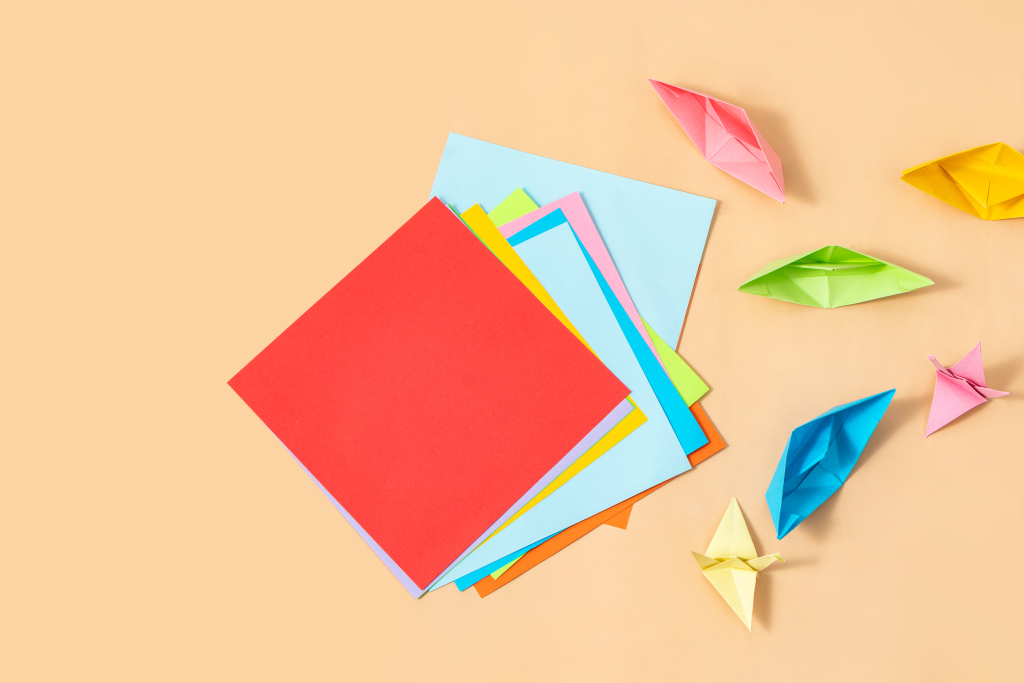 橙色桌面上的彩色折纸高清图版权图片下载