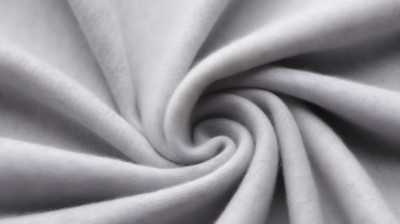 棉纤维制作的灰色毛衣面料，带有褶皱，明亮背景和逼真风格的摄影图片