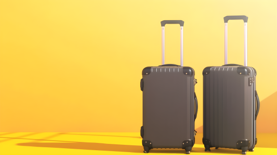 黄色背景上的两个行李箱摄影图片